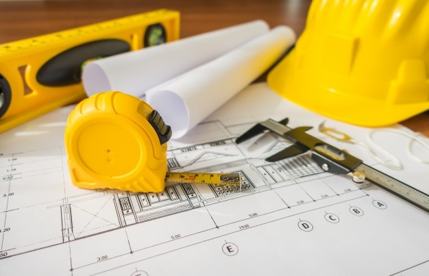 construction-plans-with-yellow-helmet-and-drawing-tools-on-bluep_1232-2940.jpg